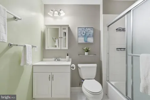 a bathroom with a toilet sink vanity and mirror