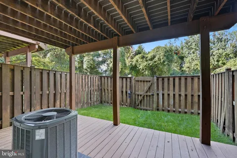 a view of a backyard with wooden fence and a porch