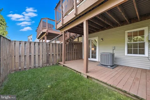 a view of a house with a yard and wooden fence