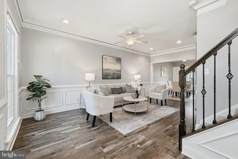 a living room with furniture a chandelier and a potted plant