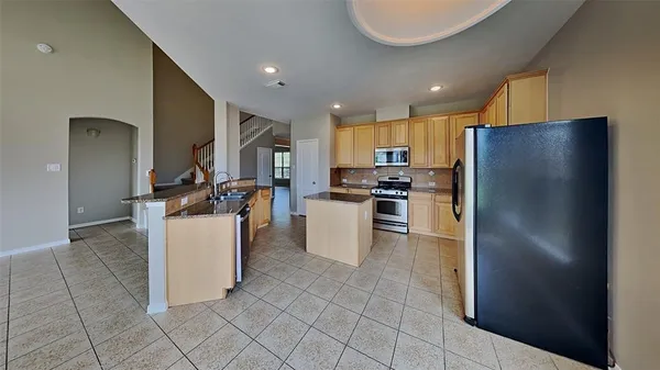 a kitchen with a refrigerator a stove top oven and a sink