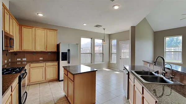 a kitchen with a sink stove top oven and refrigerator