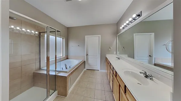 a bathroom with a double vanity sink mirror and shower