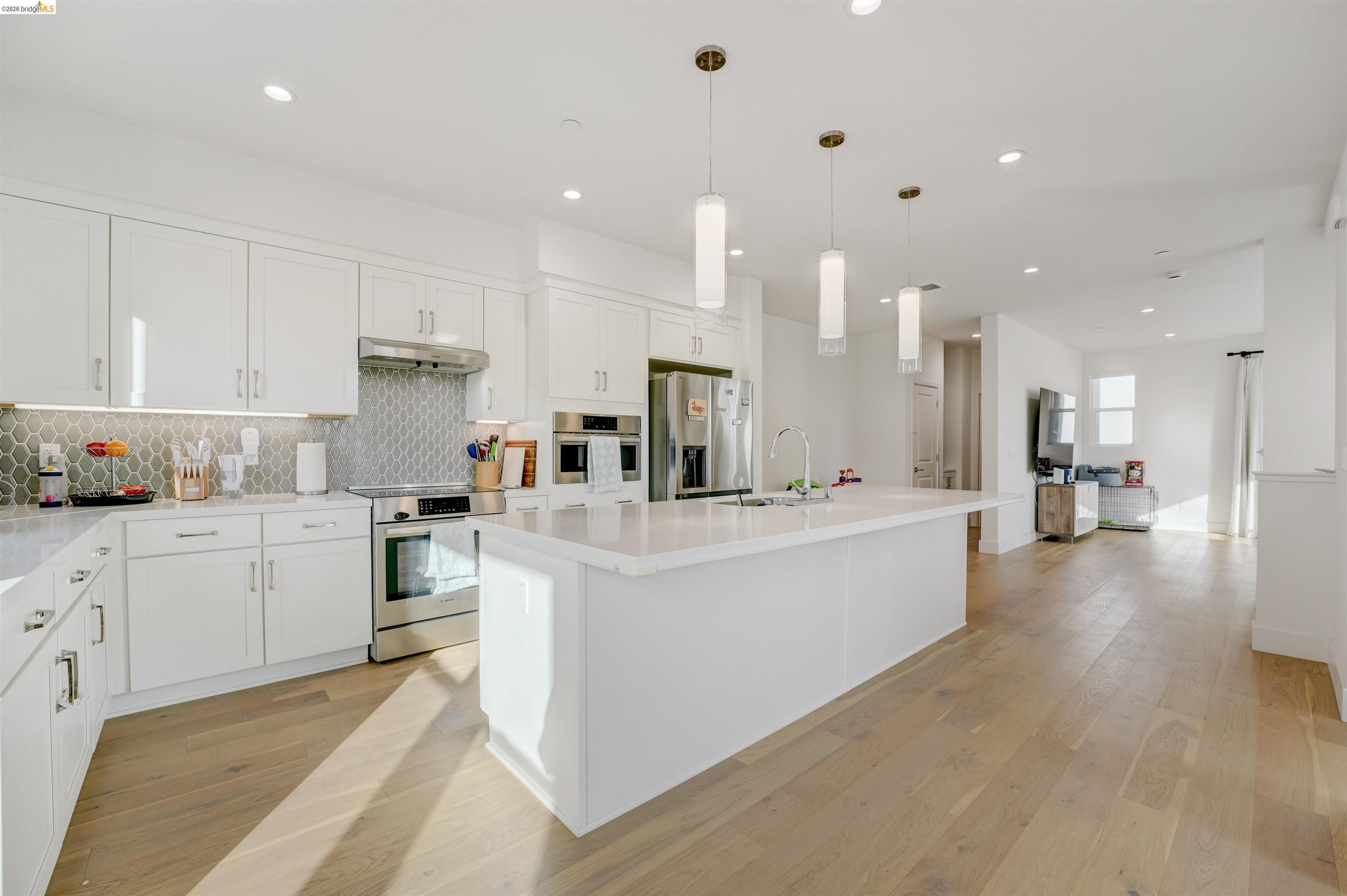 7101 Melon Court San Ramon, CA 94583 - Photo 21 of 58 a large white kitchen with kitchen island a sink a stove and a refrigerator