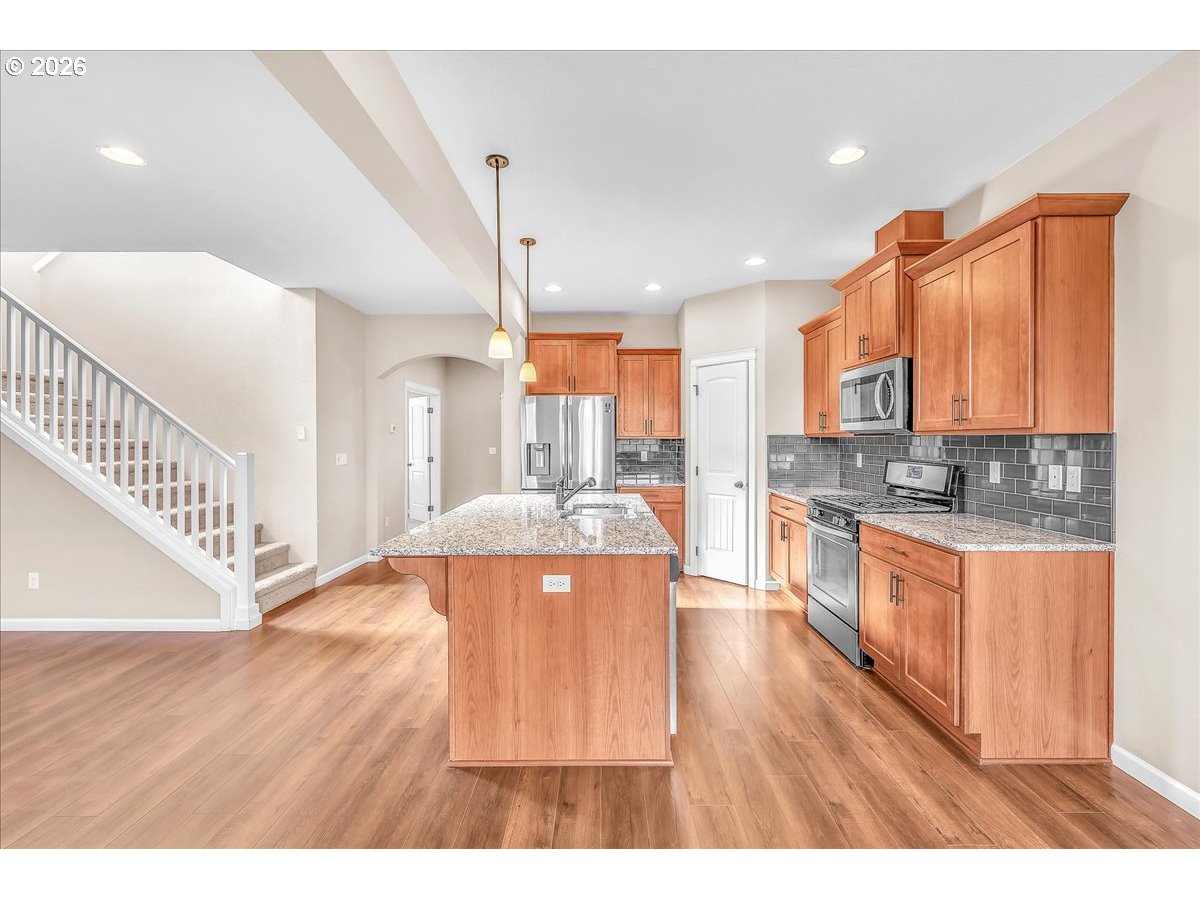 33955 Southeast Vine Street Scappoose, OR 97056 - Photo 14 of 44 a open kitchen with stainless steel appliances granite countertop a stove a sink dishwasher and a white cabinets with wooden floor