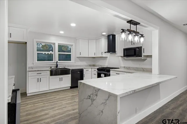 a kitchen with a stove a sink and a microwave