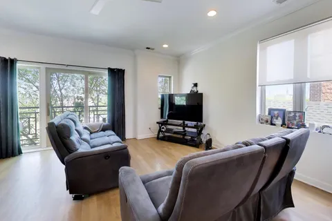 a living room with furniture a flat screen tv and a floor to ceiling window