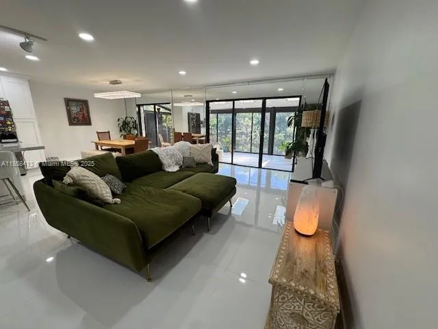 a living room with furniture and a floor to ceiling window
