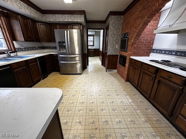 3508 Miller Road Sandusky, OH 44870 - Photo 10 of 30 Kitchen with dark brown cabinets, light countertops, crown molding, wallpapered walls, and wainscoting