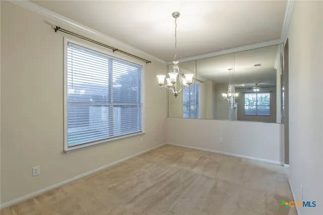 a view of a livingroom with a chandelier fan and a window