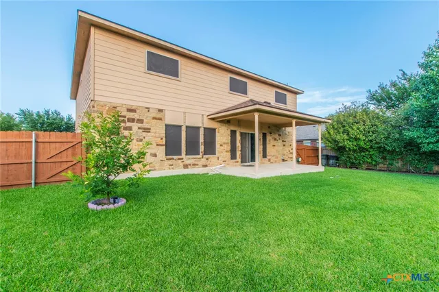 a view of a house with backyard and garden