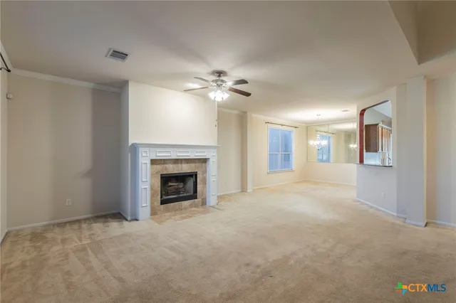 a view of a livingroom with a fireplace and a chandelier fan