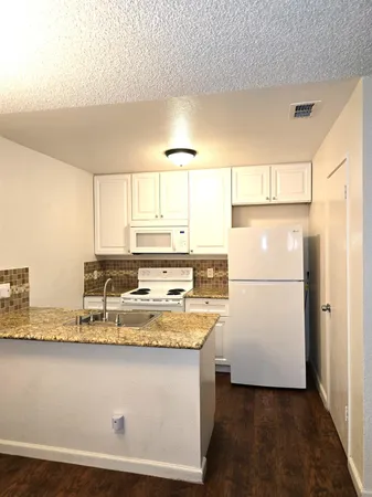 a kitchen with a refrigerator a sink and wooden cabinets