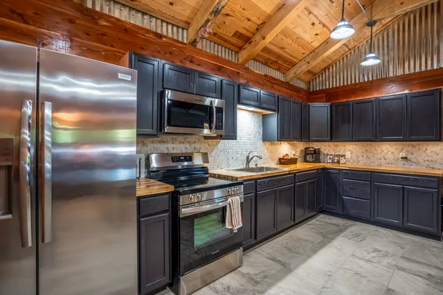 a kitchen with granite countertop a sink stainless steel appliances and cabinets