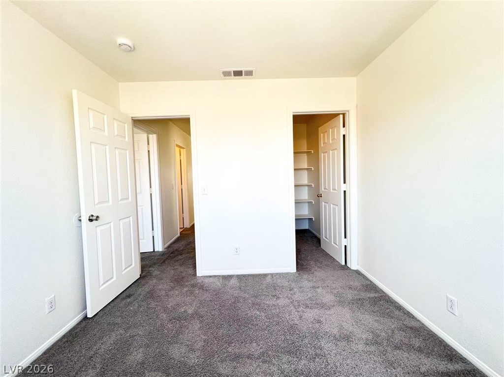 8284 West Rochelle Avenue Las Vegas, NV 89147 - Photo 24 of 29 A well-maintained carpeted room features an organized closet and convenient hallway access.
