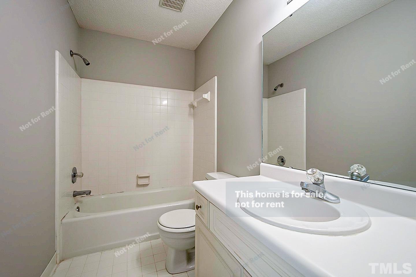 1945 Jupiter Hills Court Raleigh, NC 27604 - Photo 15 of 19 a bathroom with a toilet a sink a mirror a bathtub and shower