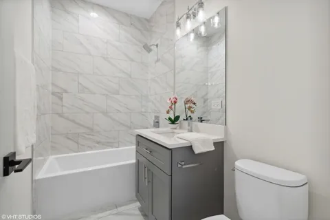 a kitchen with stainless steel appliances granite countertop a sink a stove a refrigerator and island with wooden floor