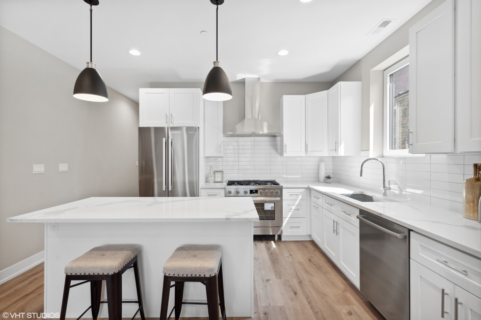 3335-3341 North Sheffield Avenue Chicago, IL 60657 - Photo 9 of 76 a kitchen with stainless steel appliances granite countertop a sink a stove a refrigerator and island with wooden floor
