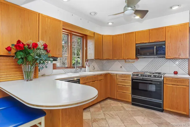 a kitchen with granite countertop a sink stainless steel appliances and cabinets