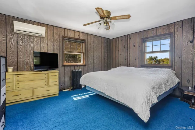 a spacious bedroom with a bed and a flat screen tv