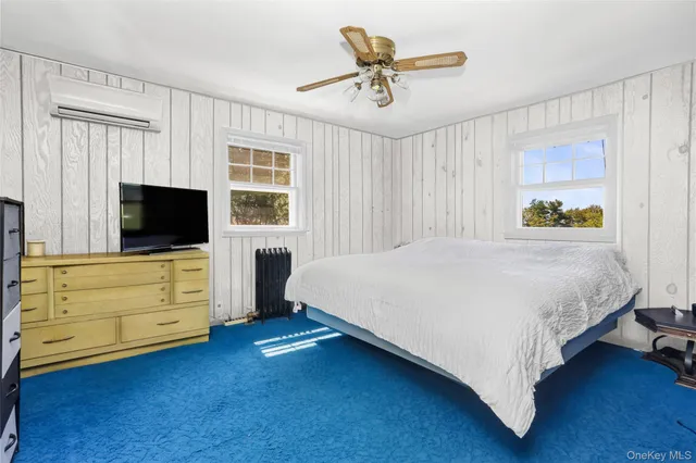 a spacious bedroom with a bed and a flat screen tv