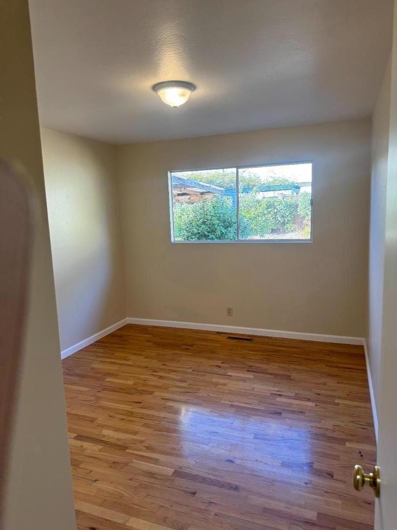 1373 Kimball Avenue Seaside, CA 93955 - Photo 7 of 13 a view of an empty room with wooden floor and a window