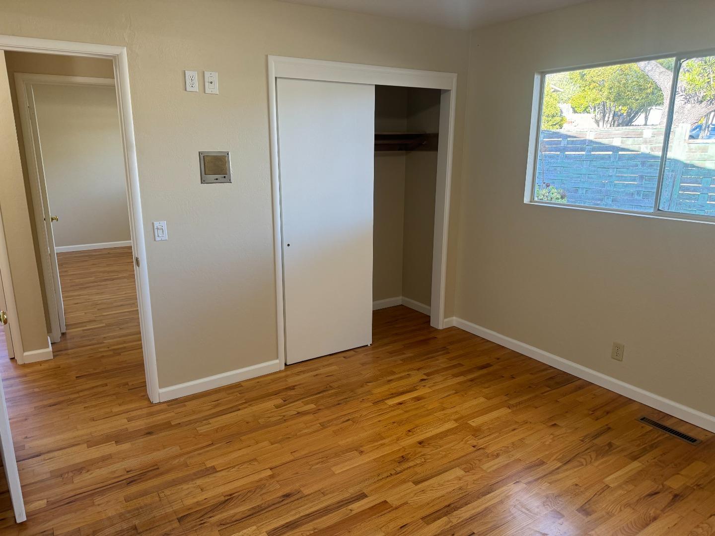 1373 Kimball Avenue Seaside, CA 93955 - Photo 9 of 13 an empty room with wooden floor and windows