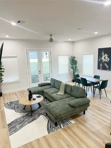 a living room with furniture and a wooden floor