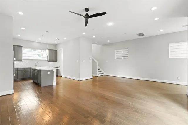 a view of an empty room with a window and kitchen view
