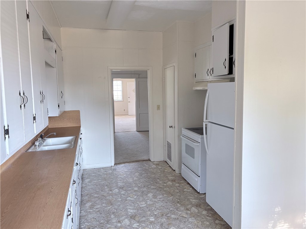 10356 Main Street Somerville, TX 77879 - Photo 12 of 19 a kitchen with white cabinets and refrigerator