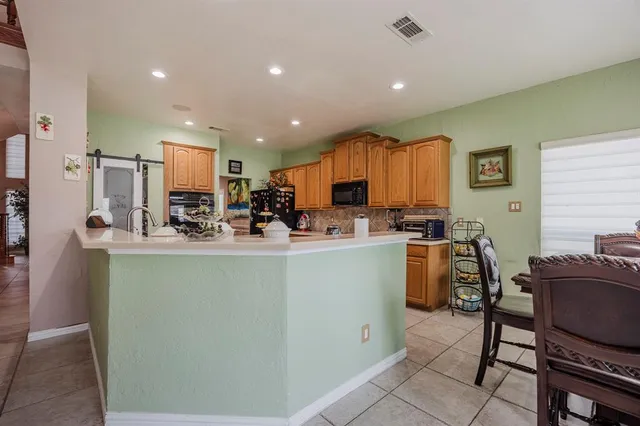 a kitchen with stainless steel appliances granite countertop a refrigerator and a stove top oven