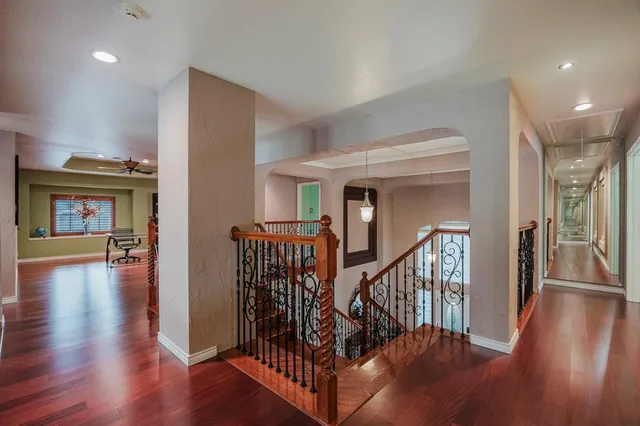 a view of a hallway with wooden floor and windows