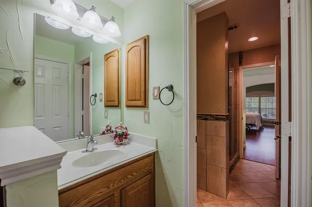 a en suite bathroom with a sink mirror and a shower