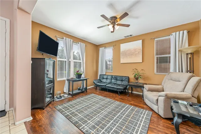 a living room with furniture a flat screen tv and a table