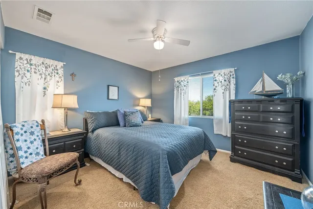 a bedroom with a bed a chandelier and dresser