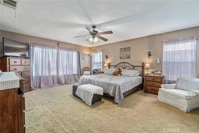 a spacious bedroom with a bed couch and window