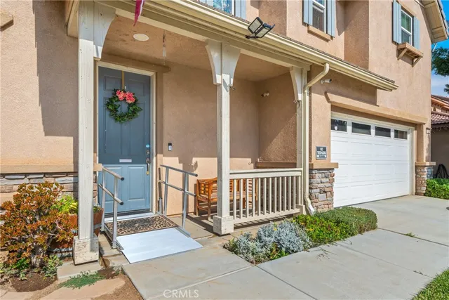 a view of a house with a small yard and potted plants