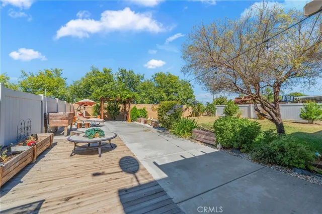 a patio with table and chairs and potted plants