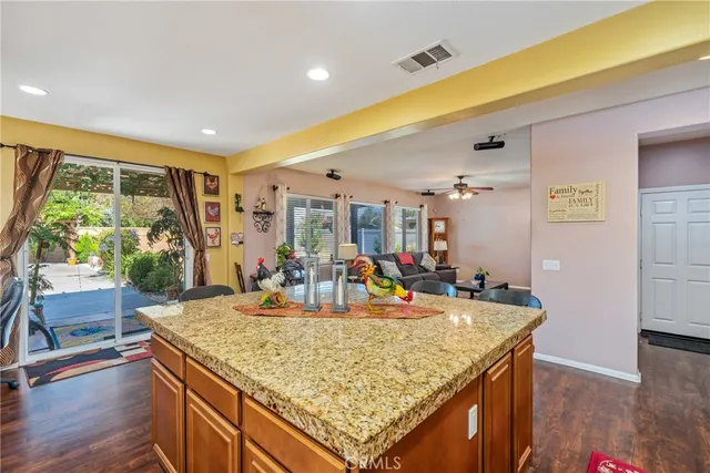 a view of kitchen island with stainless steel appliances granite countertop sink and wooden floor