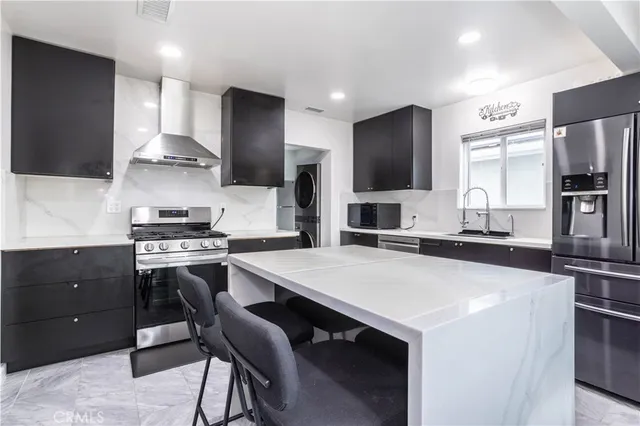 a kitchen with stainless steel appliances a stove refrigerator sink and cabinets