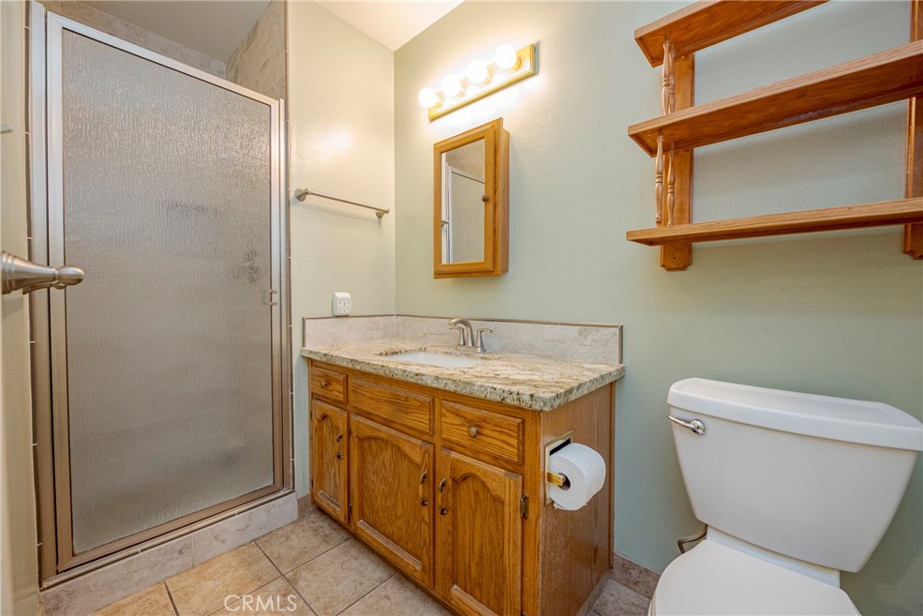 3449 Bautista Court Merced, CA 95348 - Photo 36 of 41 a bathroom with a granite countertop toilet sink and mirror