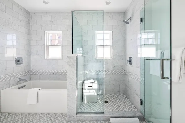 a bathroom with a granite countertop sink a toilet and shower