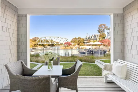 a view of a dining room with furniture a rug and a floor to ceiling window