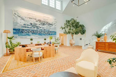 a living room with furniture a chandelier and a table