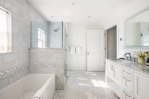 a bathroom with a granite countertop tub sink and mirror