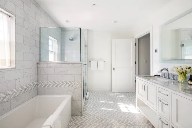 a bathroom with a granite countertop tub sink and mirror