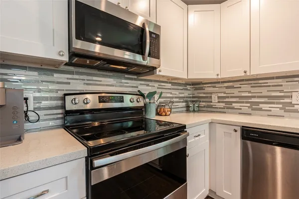 a kitchen with a dining table chairs wooden floor appliances and cabinets