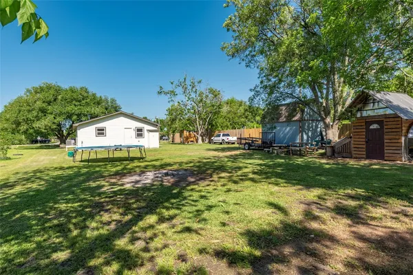 a view of backyard with barbeque grill and wooden fence