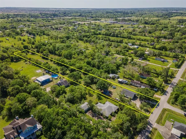 an aerial view of residential house with outdoor space and trees all around