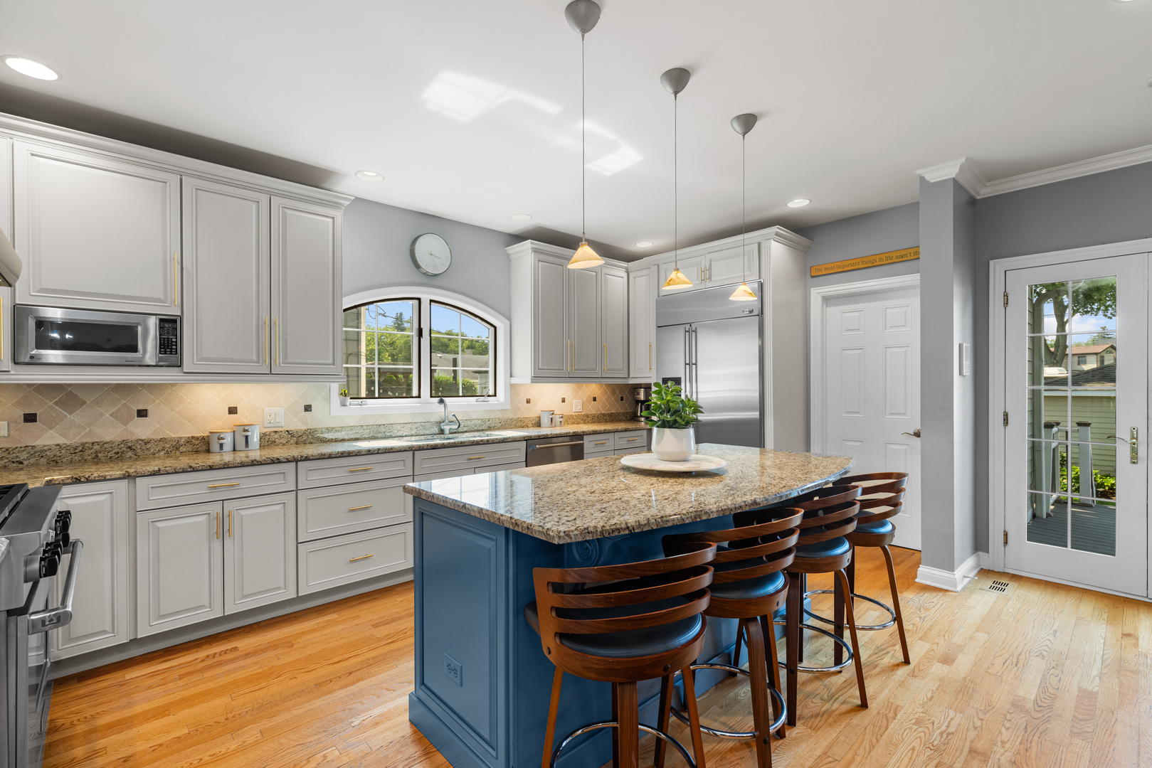 6972 West Imlay Street Chicago, IL 60631 - Photo 14 of 42 a kitchen with kitchen island granite countertop a table chairs sink and cabinets